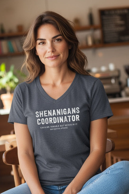 Woman wearing a t-shirt with 'SHENANIGANS COORDINATOR' text in a casual setting.